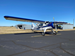 A blue-trim vintage taildragger on the ramp.