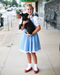 Girl dressed up as Dorothy from the Wizard of Oz and holding Toto
