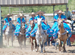Women in blue dresses and sombrous on horses during a Rodeo