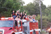 High school kids on top of a fire truck during a parade