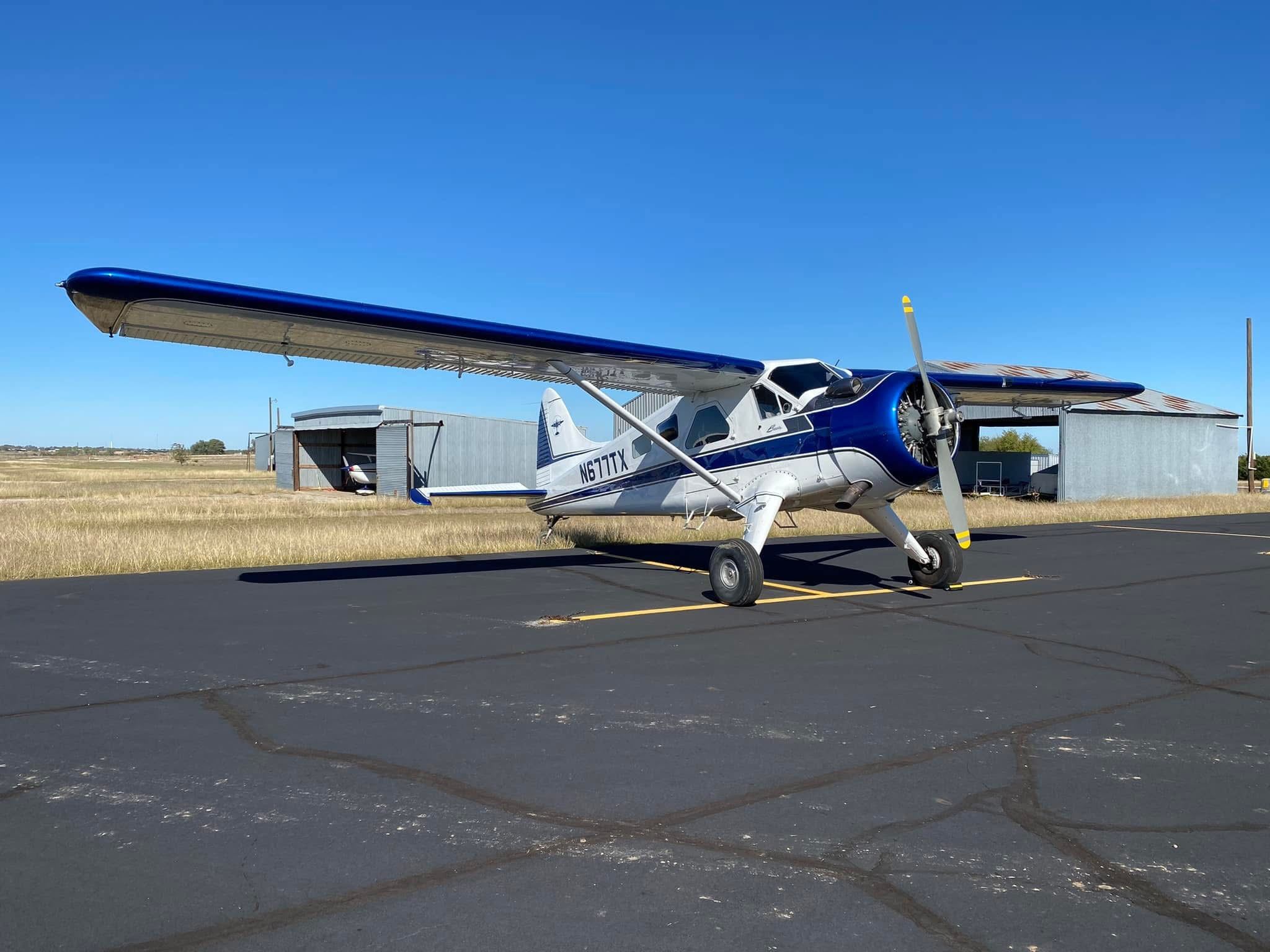A blue-trim vintage taildragger on the ramp.