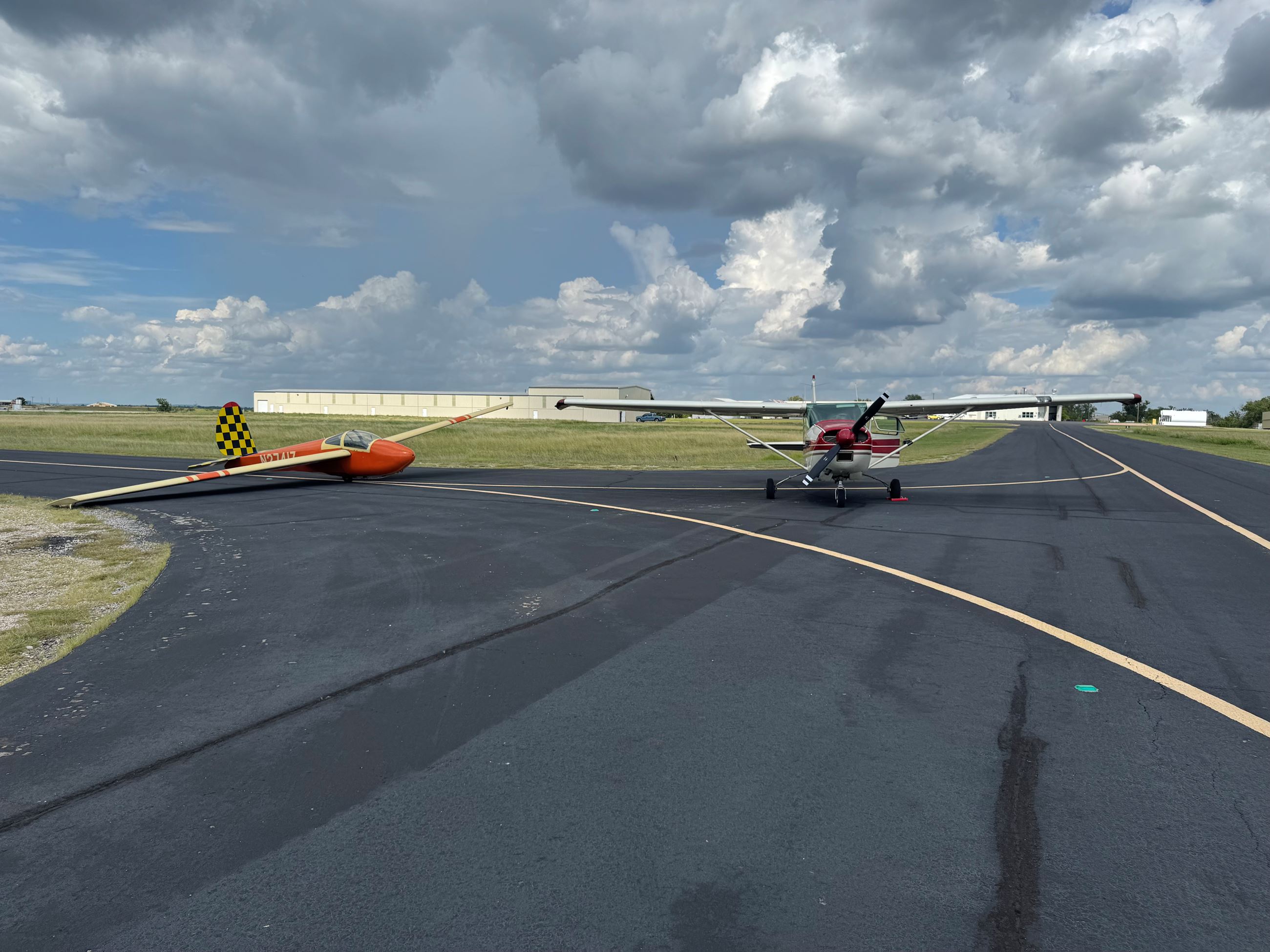 Towplane and orange glider staged for a launch.