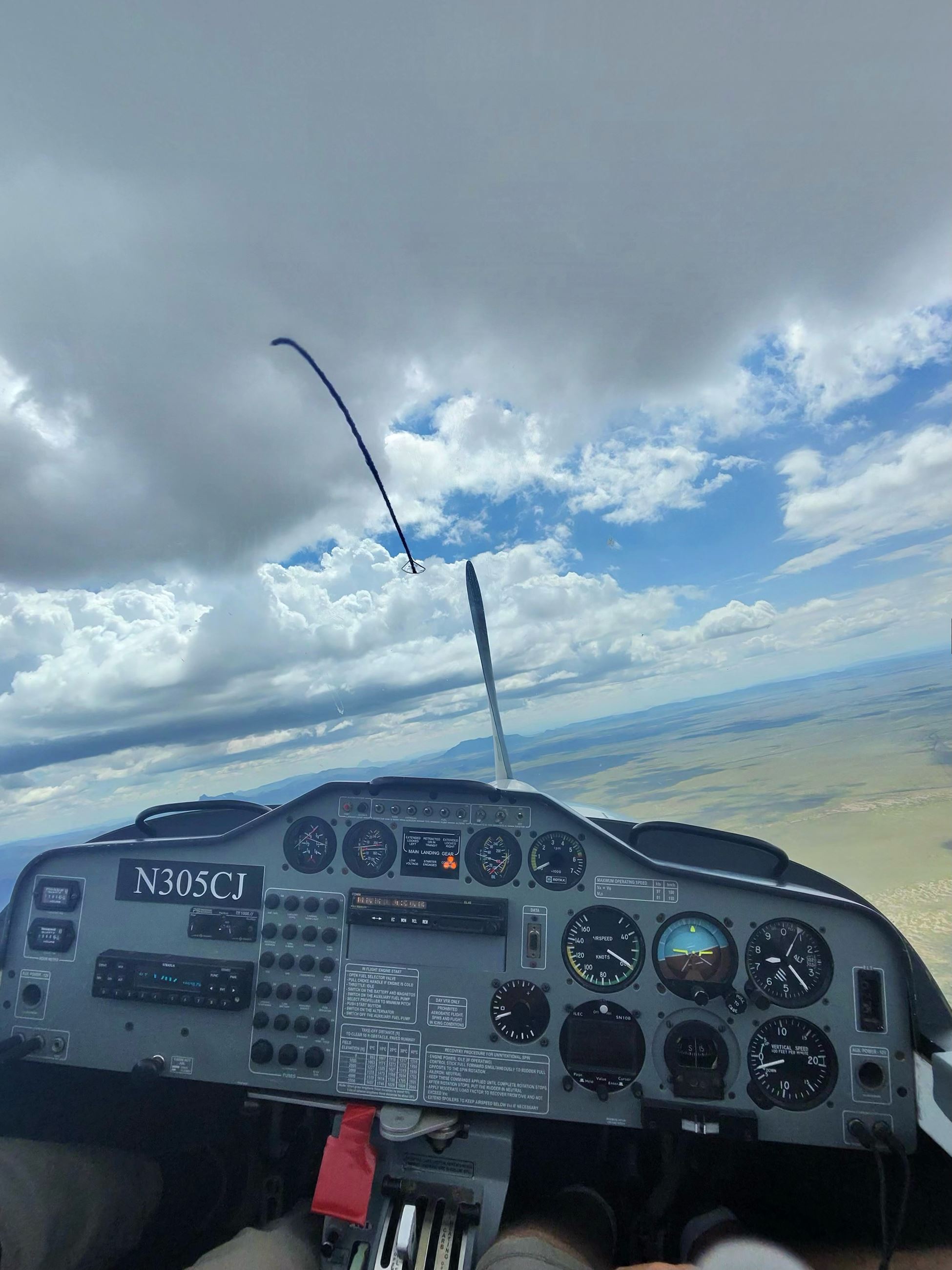 Glider cockpit panel and yaw string beneath cumulus.