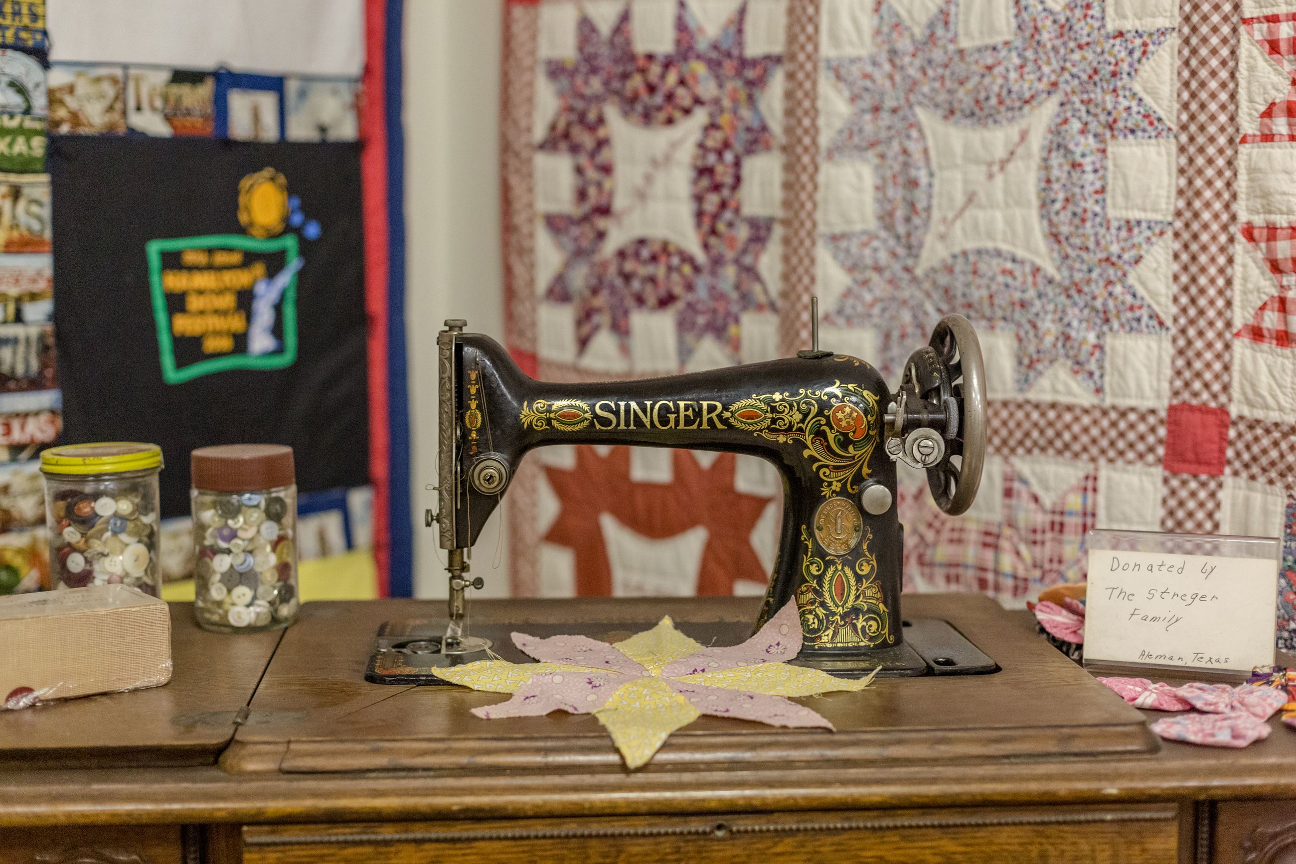 Vintage sewing machine and quilt display showcasing early 20th-century textile craftsmanship in Hamilton County.